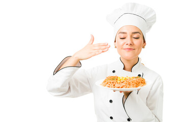 Professional chef holding a plate of spaghetti a restaurant