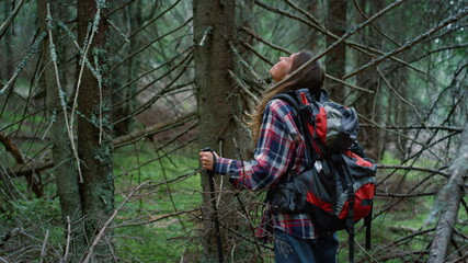 Naklejka premium Tourist standing in summer forest. Girl taking rest in woods during hike