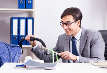 Businessman looking after newborn baby in office