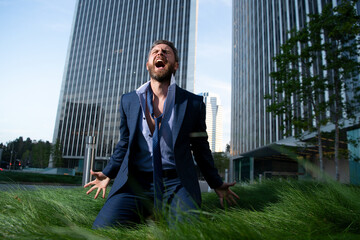 Depressed businessman sitting outside office. World economy hit. Financial crisis concept.