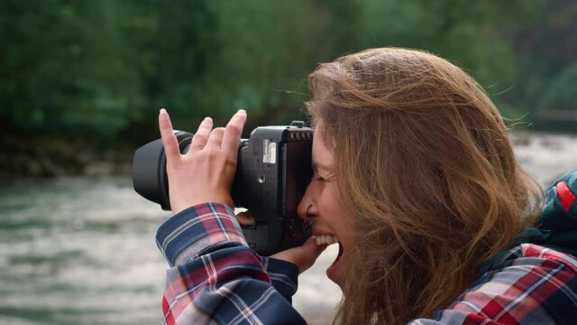 Photographer taking pictures of nature. Excited woman using photo camera outdoor