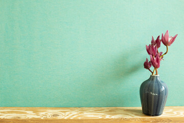Vase of cymbidium flower on wooden table. green background