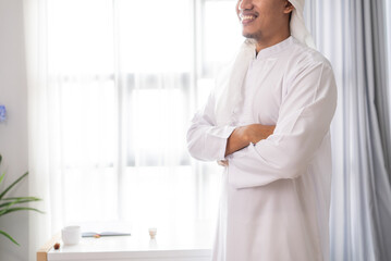 Naklejka na ściany i meble arabic muslim businessman standing portrait crossed his arm against the window