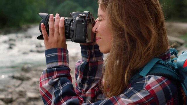 Photographer taking photos of nature. Attractive woman using photo camera