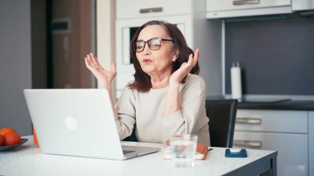 Senior mature older woman making a business training, online webinar on a laptop computer remote working. 60s businesswoman video conference calling in virtual chat.