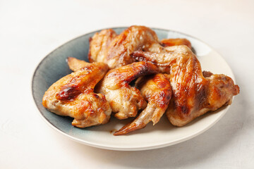 Chicken wings grill  in a plate on a bright background.