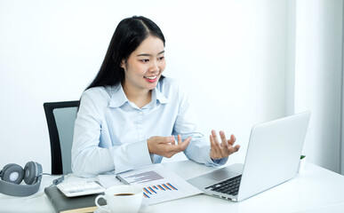 Asian female accountant sits at their desks and calculates financial graphs showing results about their investments, plan a successful business growth process