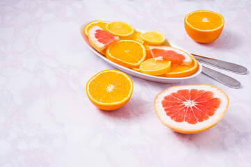 Plate with citrus fresh fruits on a white background. High in antioxidants, vitamins, dietary fibre and anthocaynins.