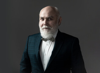 Confident senior bearded man in a suit and tie stand on gray isolated background. Fashion posing adult man in fashion suit.