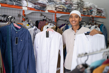 Fototapeta na wymiar Portrait of a young asian muslim man shopping for clothes at store