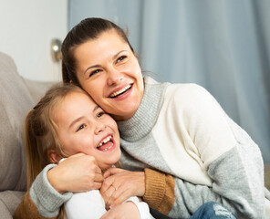 Happy family woman with small daughter laughing at home interior