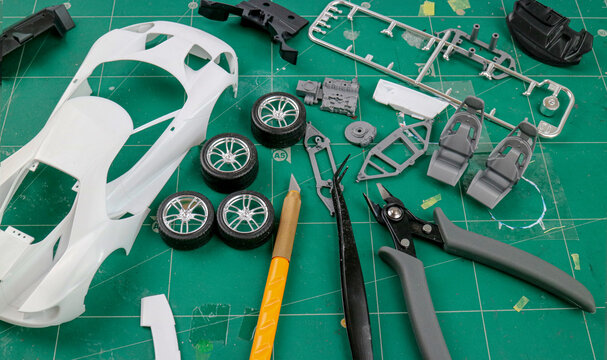 Top view of Assemble car plastic model for hobbyists , scale model of a sport car, Hobby and leisure at home in quarantine.