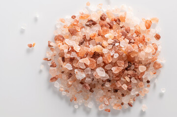 pink Himalayan coarse salt on a white background, close-up, top view