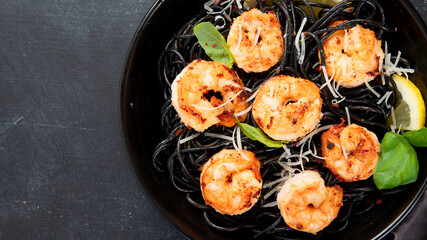 Spaghetti with shrimps and parmesan on dark background. Tasty appetizings seafood pasta.