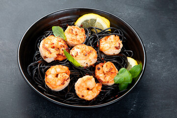 Spaghetti with shrimps and parmesan on dark background. Tasty appetizings seafood pasta.