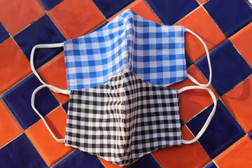 Fototapeta premium Face mask Plaid pattern in black, blue, white It is used for airborne pm2.5 dust prevention and prevention of infection with covid-19 or coronavirus. Placed on the back of orange and blue plaid