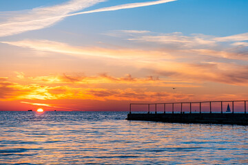Obraz premium Beautiful sunset on the sea coast. The sun reflecting on the sea. Nature background.