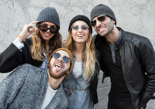 Portrait Of Young People Posing With Funny Faces And Unconventional Grimaces. Trendy Millennials Have Fun Together Joking Outdoors.