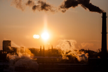 Fototapeta premium steam from a pipe in the light of dawn, urban landscape
