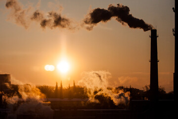 Fototapeta premium steam from a pipe in the light of dawn, urban landscape