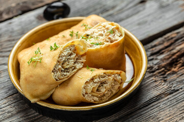 Savory crepe rolls with ground chicken meat. Pancakes with chicken on a wooden table, Long banner format, top view