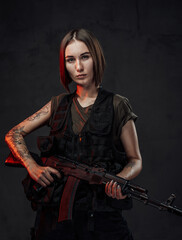 Armed with rifle attractive woman in dark background