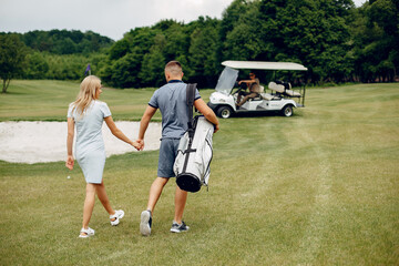 Obraz premium Beautiful couple playing golf on a golf course