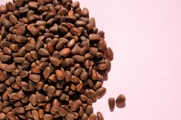 Pine nuts heap on a pink background. Nuts and seeds.  cedar nuts. Organic and healthy superfood.