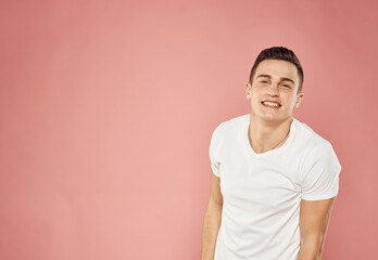 handsome man in white t-shirt emotions joy pink background