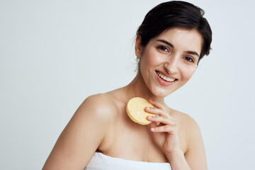 Beautiful brunette with a sponge in her hands white towels clean skin care