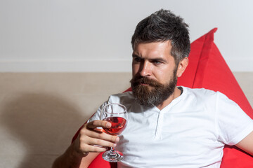 Bearded hipster with wine. Home party. Man with alcohol. Bearded man with glass of wine. Casual fashion.