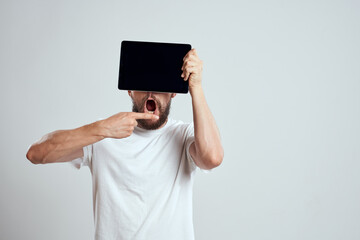 A bearded man in a white t-shirt a tablet in the hands of a professional manager communication technology