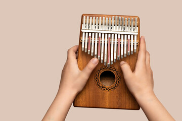 Fototapeta na wymiar Folklore musical instruments concept. The child holds Kalimba in his hands and plays it like a piano.