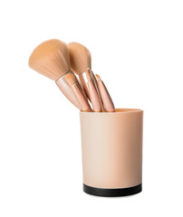 Cup with stylish makeup brushes on white background