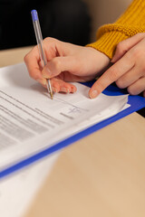 Close up of businesswoman signing investment papers contract with confident partner sitting at desk in startup company. Entrepreneur taking bank loan insurance concept, patent certificate registration