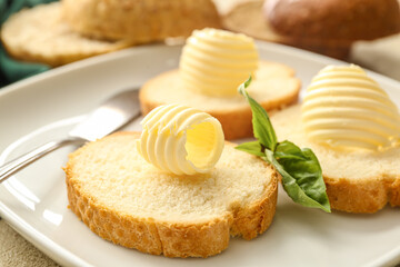 Slices of fresh bread with butter on plate, closeup