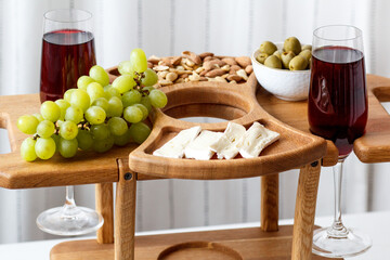 Serving wooden table for wine, glasses and snacks. Handmade segmented Portion wooden table. Grapes, cheese, wine and nuts.  