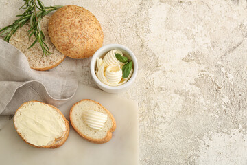Bowl with fresh butter with basil and bread on light background