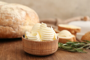 Bowl with fresh butter on wooden background