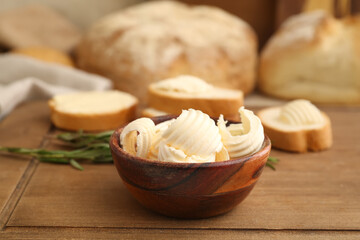 Bowl with fresh butter on wooden background