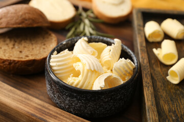 Bowl with fresh butter on wooden background