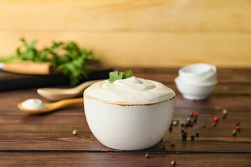Bowl of tasty sour cream on wooden background