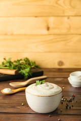 Fototapeta na wymiar Bowl of tasty sour cream on wooden background