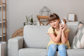 Fototapeta premium Cute little girl with chocolate Easter egg at home