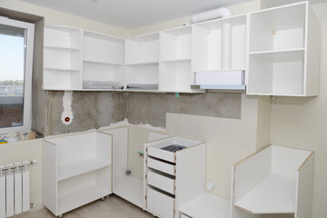 Assembly of white kitchen furniture in a renovated room