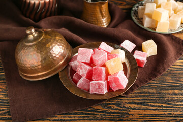Fototapeta na wymiar Plate with Turkish delight on wooden background