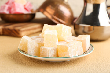 Plate with Turkish delight on color background