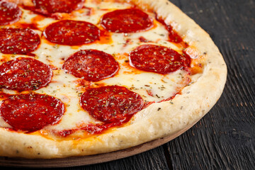 Fresh baked pepeproni pizza on the wooden background
