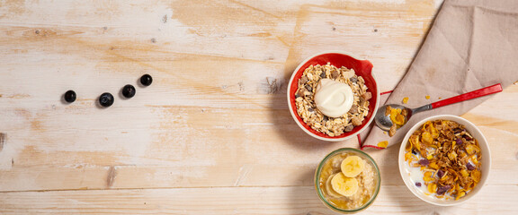 Three bowls with healthy breakfast on wooden background 