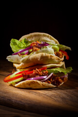 Homemade flatbread sandwich, kebab or doner with chicken meat, lettuce and vegetables